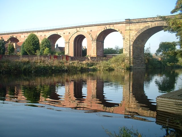 Yarm Viaduct's brick and stone arches reflected in the still River Tees